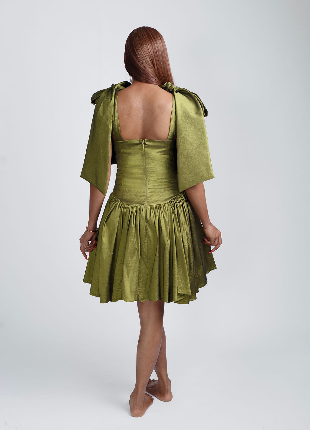 Back view of Fashion-forward Green mini bow-strap dress with elegant shoulder bows and a playful above-the-knee fit. Perfect for summer parties, brunch dates, and special occasions. Shop trendy women’s dresses, chic summer outfits, and 2025 fashion must-haves at Kaiiko and Virgo.