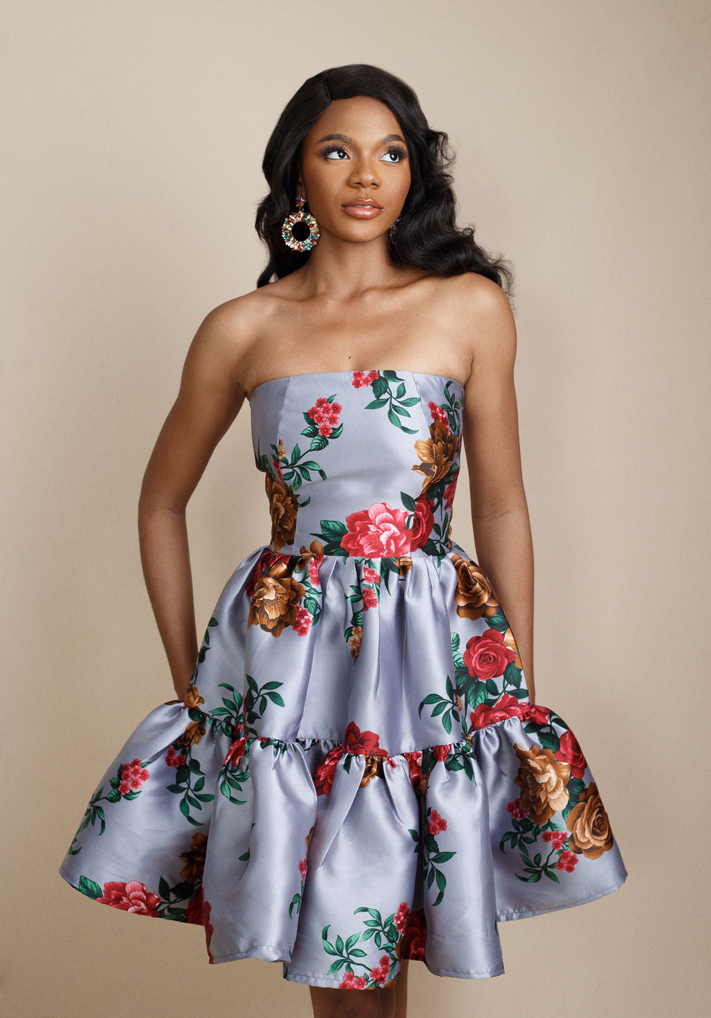 Stylish grey strapless floral dress with bold red flower prints, featuring a flirty flared skirt above the knee. Ideal for weddings, cocktail parties, and special occasions. Discover elegant occasion dresses and trending women’s fashion for 2025 at Kaiiko and Virgo.